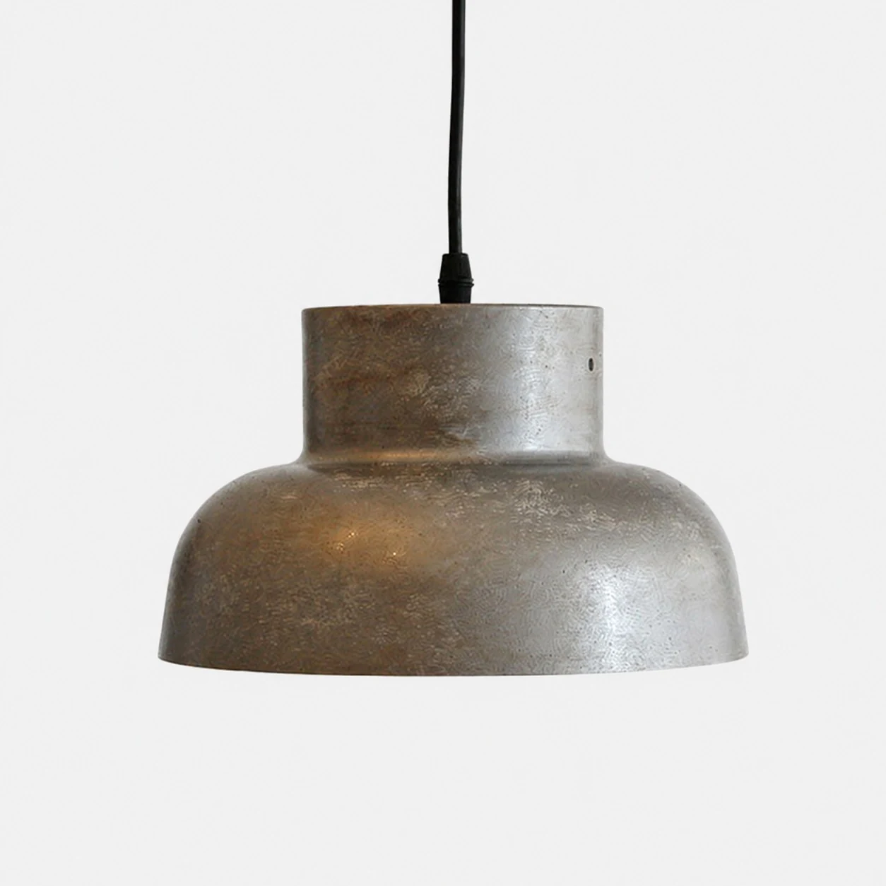 Lampadario industriale in metallo anticato su sfondo neutro.